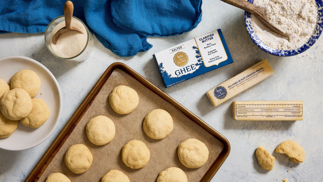 Soft & Chewy Sugar Cookies on a baking sheet next to 4th & Heart butter sticks.