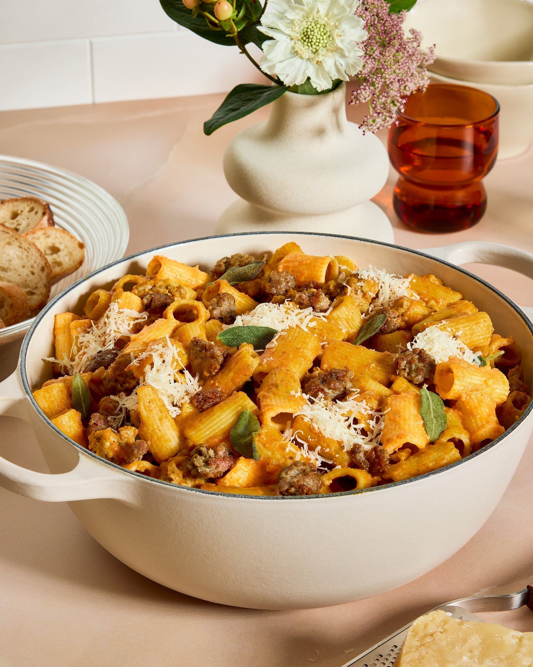 A large serving bowl full of Creamy Pumpkin Rigatoni with Sausage and Sage.