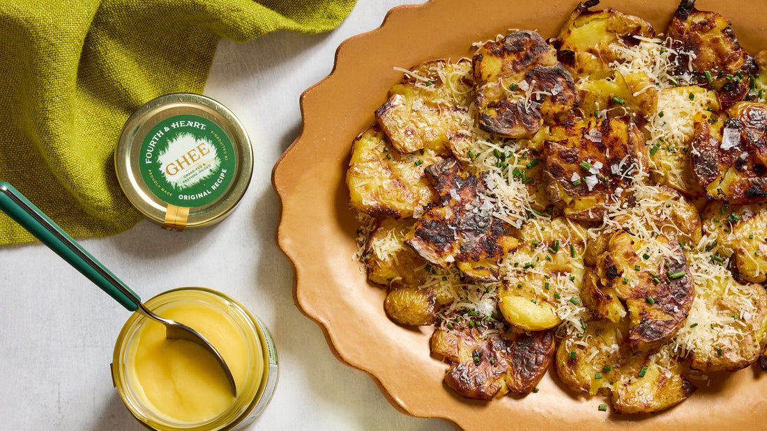 Roasted Smashed Potatoes on a serving platter next to a jar of 4th & Heart ghee.