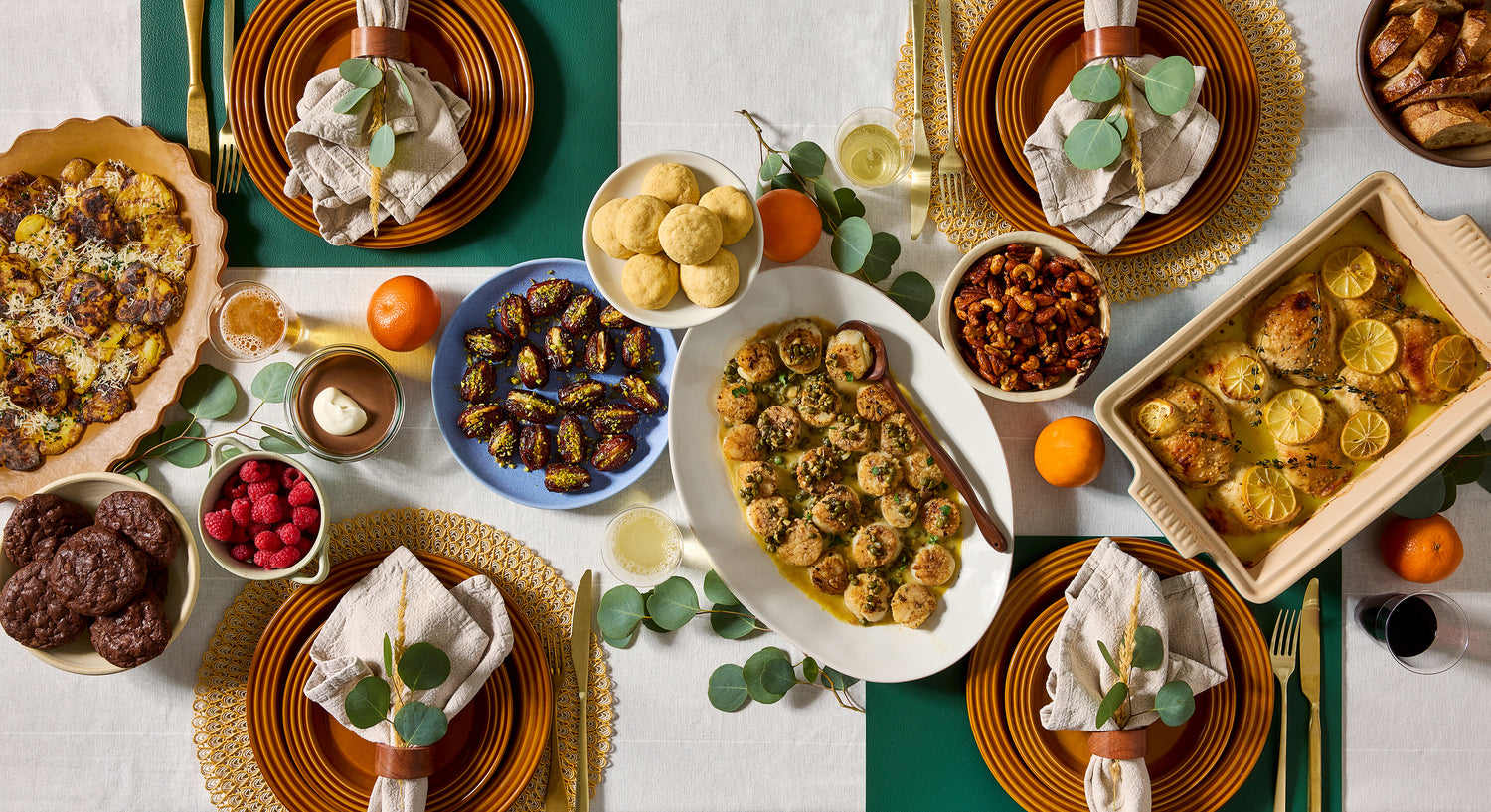 Diverse array of food items on a table with a focus on a central dish of scallops.